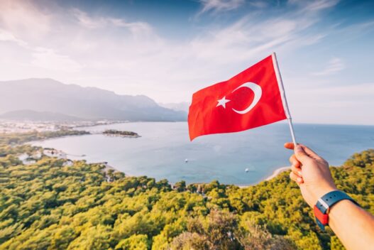 Person på ferie i Tyrkiet som holder det tyrkiske flag i hånden